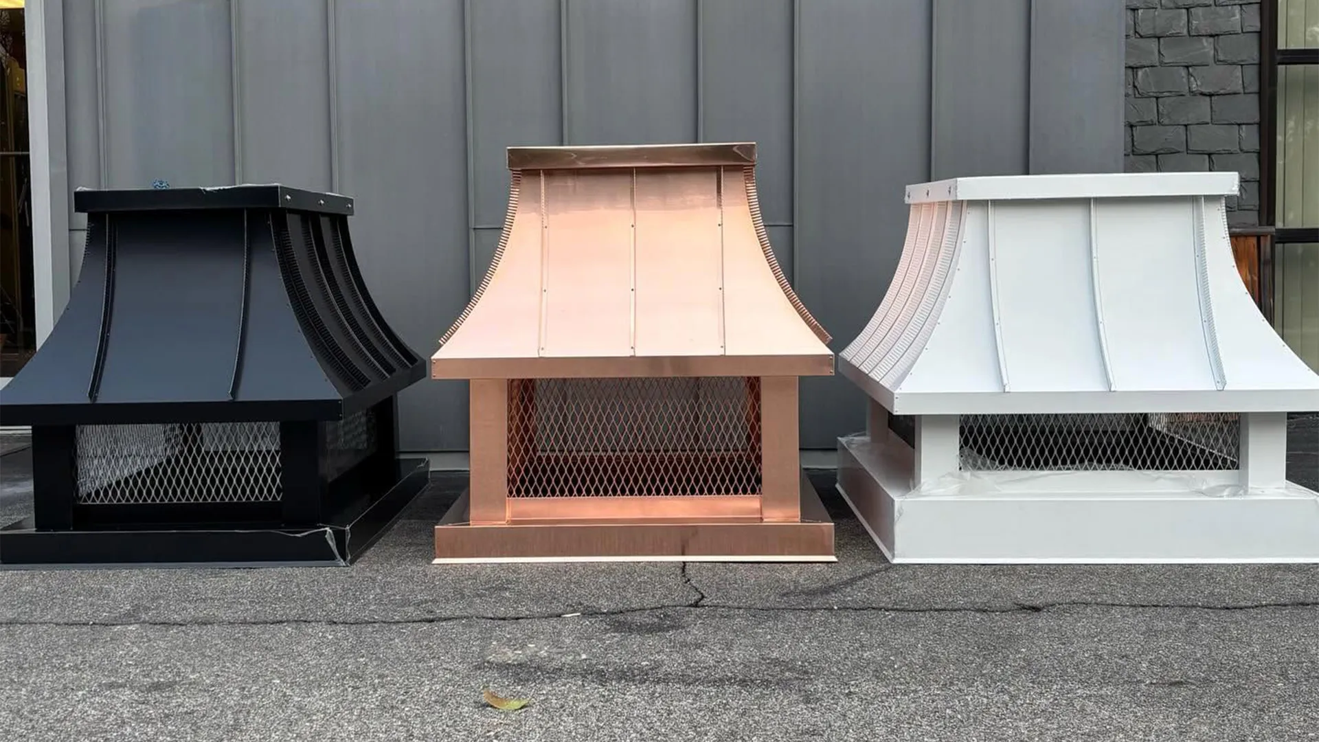 Concave-roof chimney caps in black, copper and white