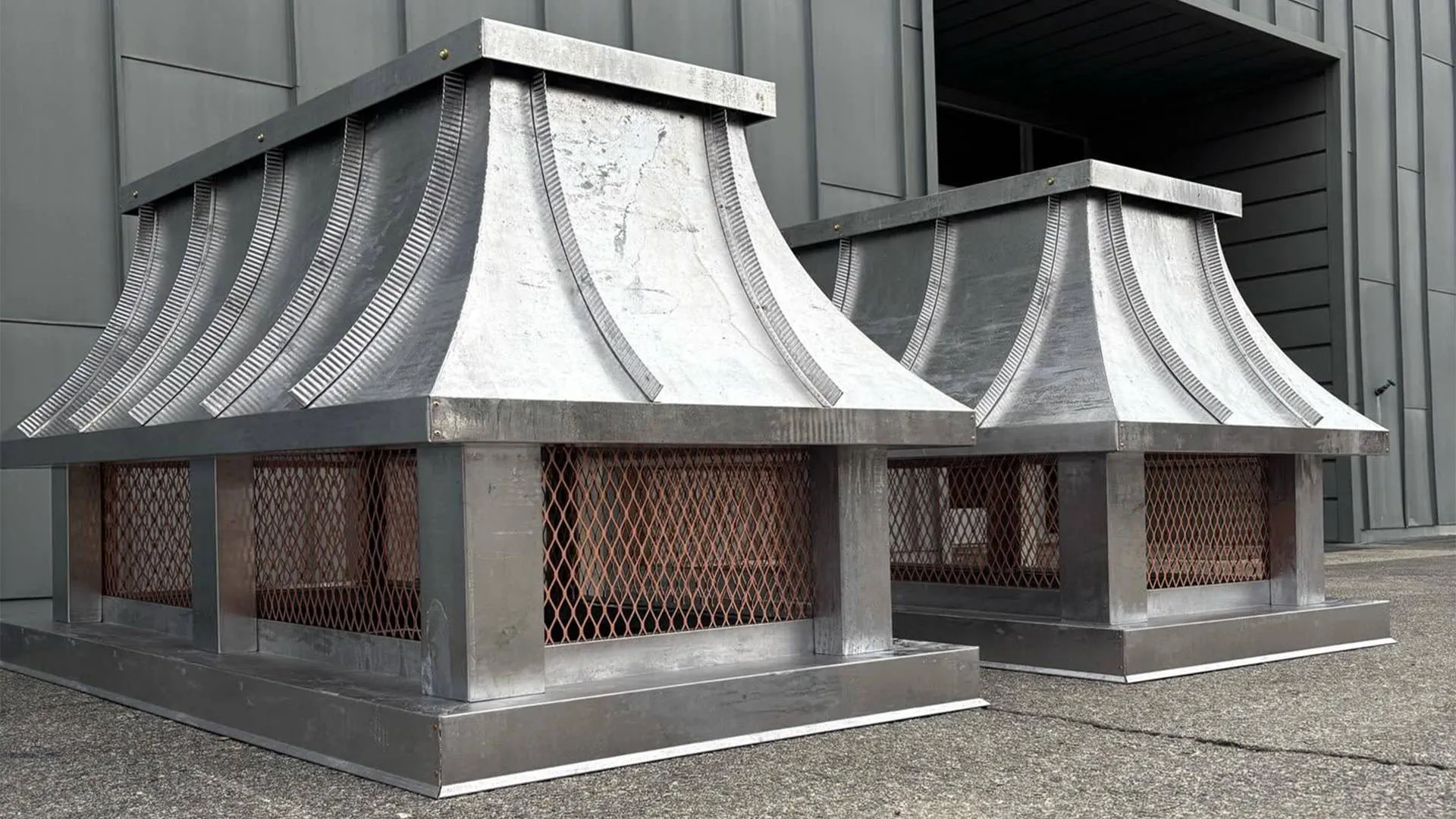 Side-mount concave-roof chimney cap with a lead-coated finish