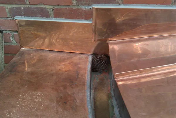 Copper Gutter Outlet Strainer Copper wire strainer installed in a custom built-in copper gutter